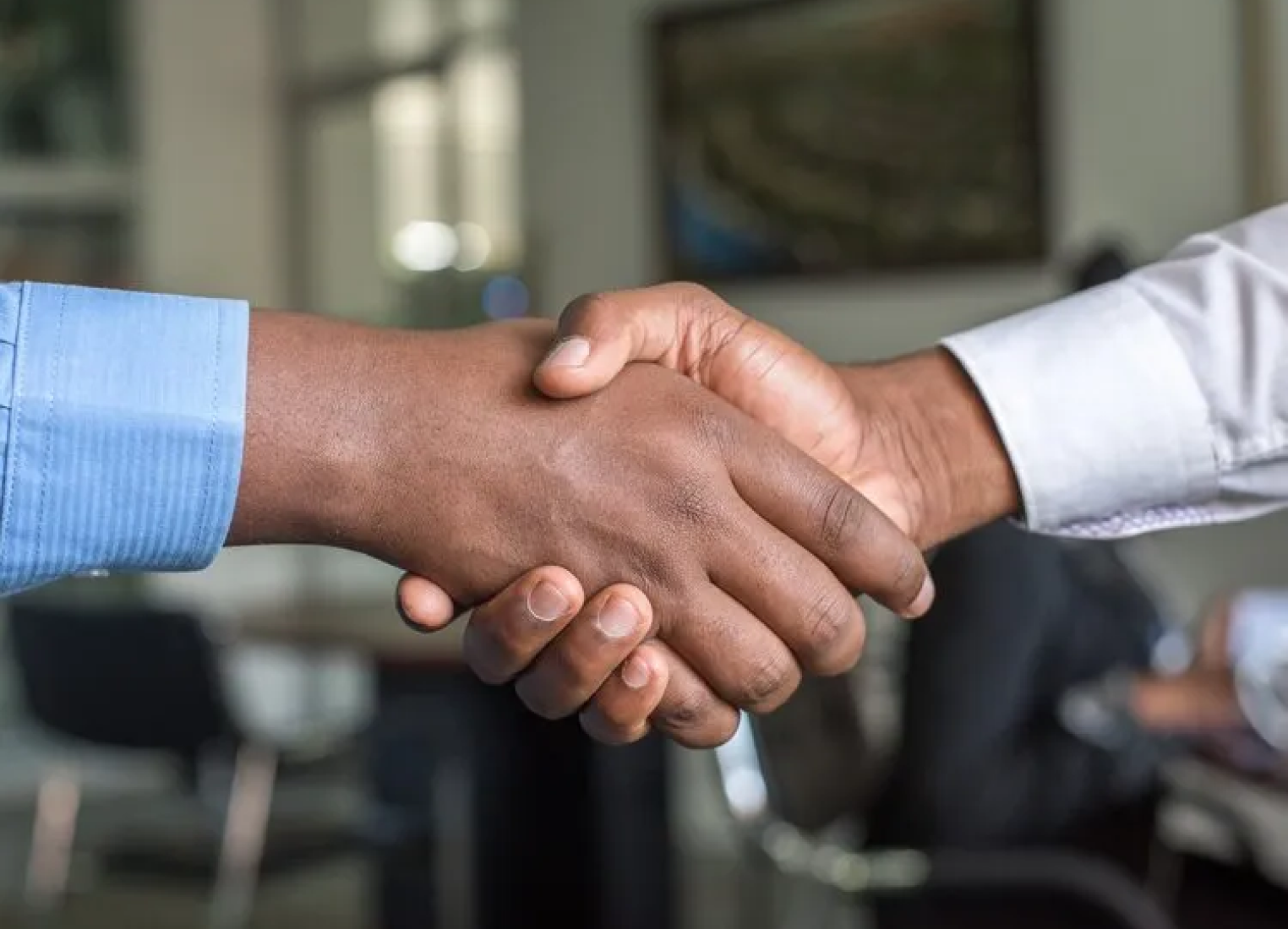 Two men are shaking hands in an office.