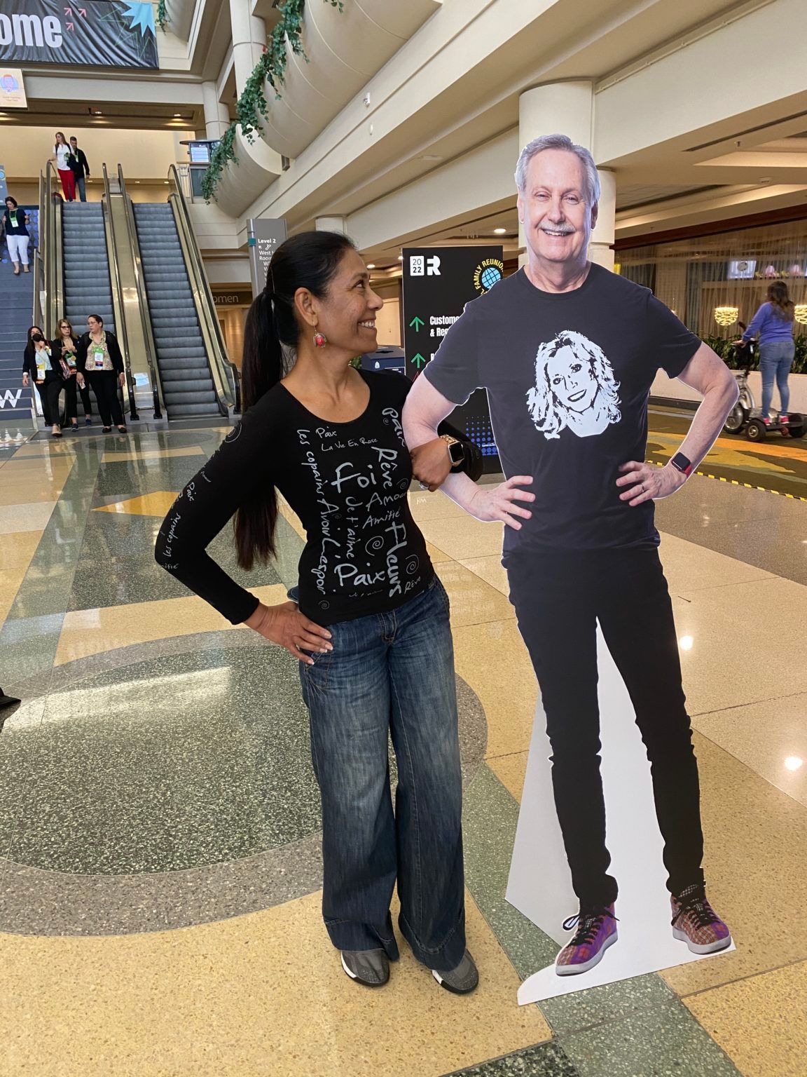 A woman standing next to a cardboard cutout of a man