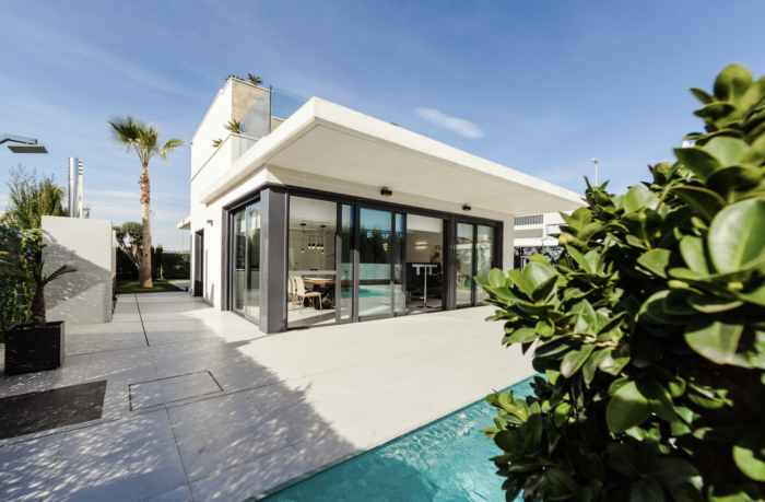 A modern house with a swimming pool in front of it.