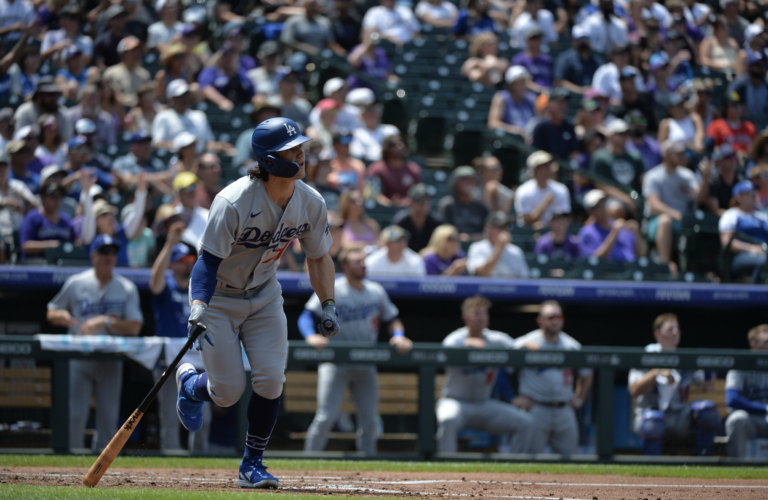 A baseball player is running towards home plate during a game.