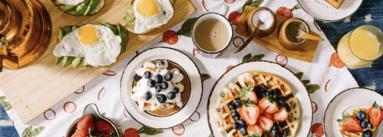 A table topped with plates of food and drinks.