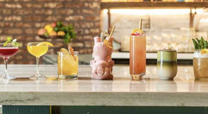 A variety of drinks are lined up on a bar counter.