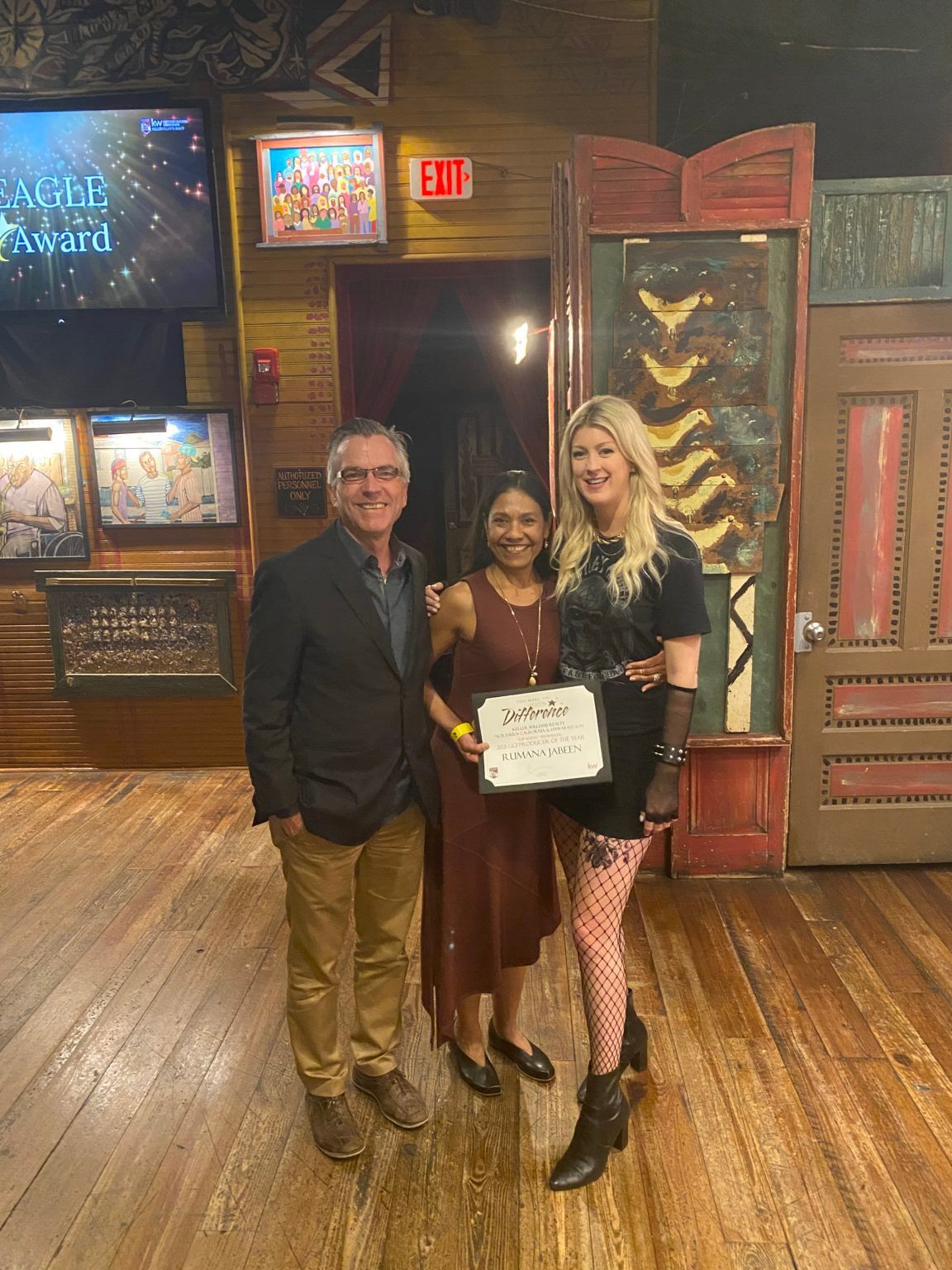 A man and two women are posing for a picture in a room.