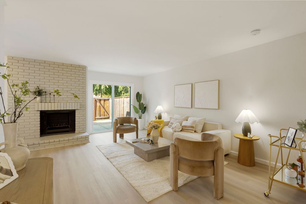 Open-concept living and dining area with vinyl plank floors, large sliders, and brick fireplace, listed by Foster City Realtor Rumana Jabeen.