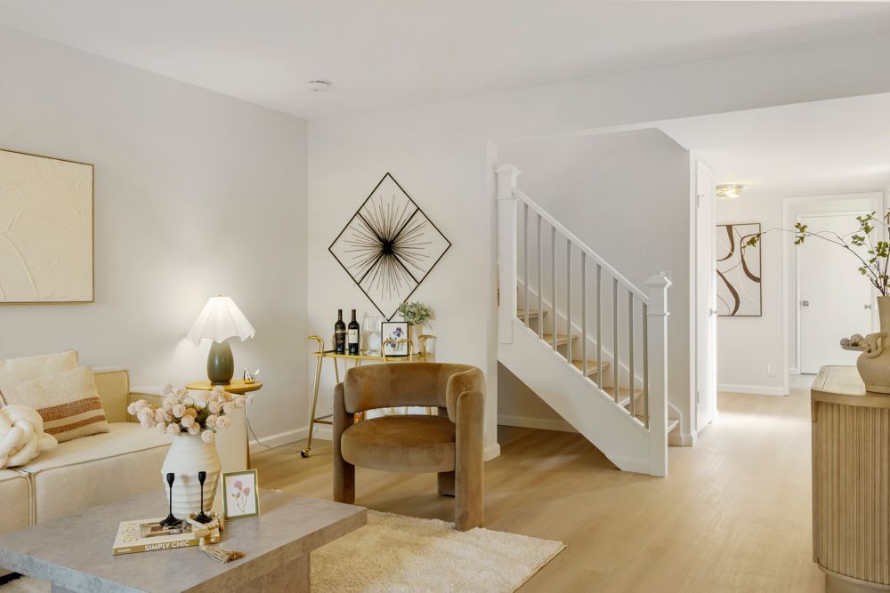 Open-concept living and dining area with vinyl plank floors, large sliders, and brick fireplace, listed by Foster City Realtor Rumana Jabeen.