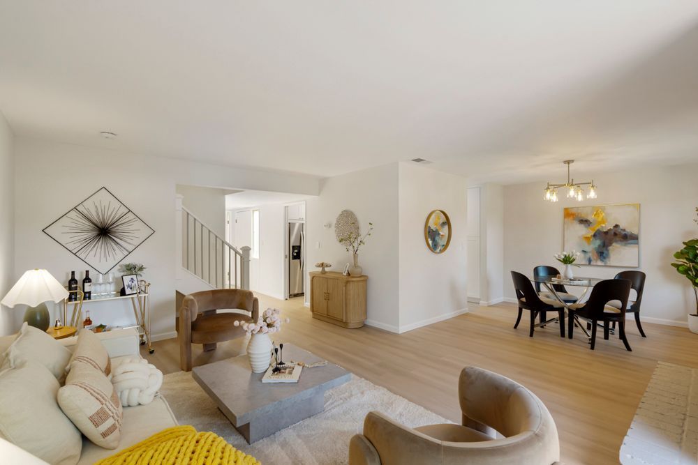 Open-concept living and dining area with vinyl plank floors, large sliders, and brick fireplace, listed by Foster City Realtor Rumana Jabeen.