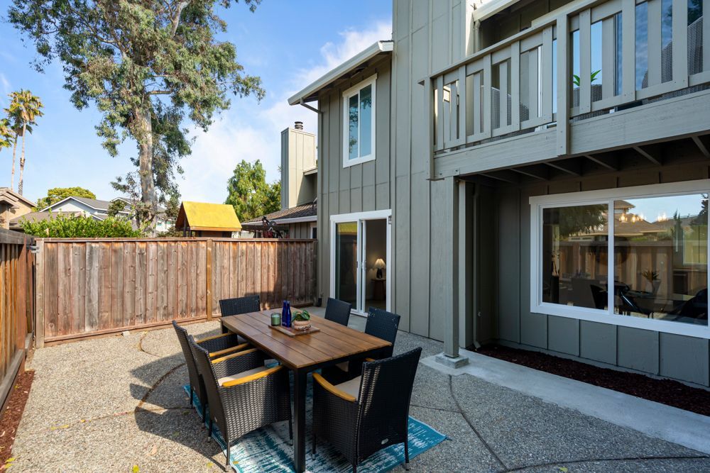 Private backyard patio with wood fencing and direct access to landscaped community greenbelt, listed with Foster City Realtor Rumana Jabeen.