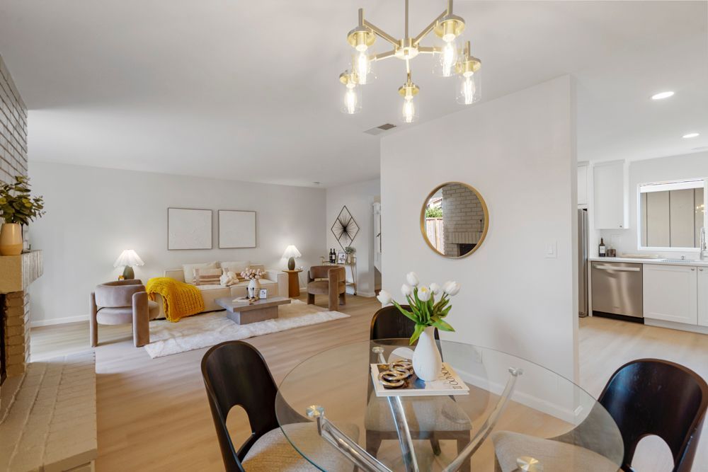 Dining area with chandelier and greenbelt views, offering natural light and an inviting atmosphere, presented by Rumana Jabeen Real Estate.