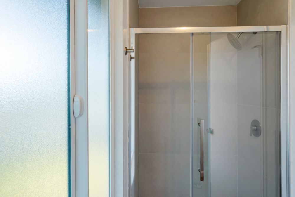 Updated primary bathroom with quartz vanity, glass shower, and walk-in closet, listed with Foster City Realtor Rumana Jabeen.