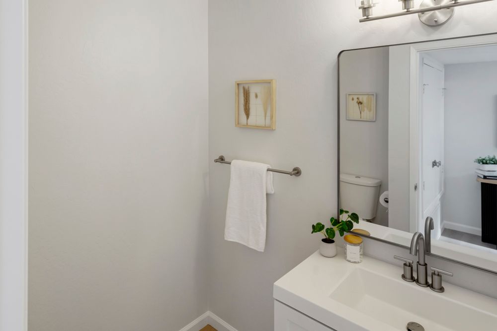 Updated hallway bath with modern vanity and starburst tile flooring, presented by Rumana Jabeen Real Estate.