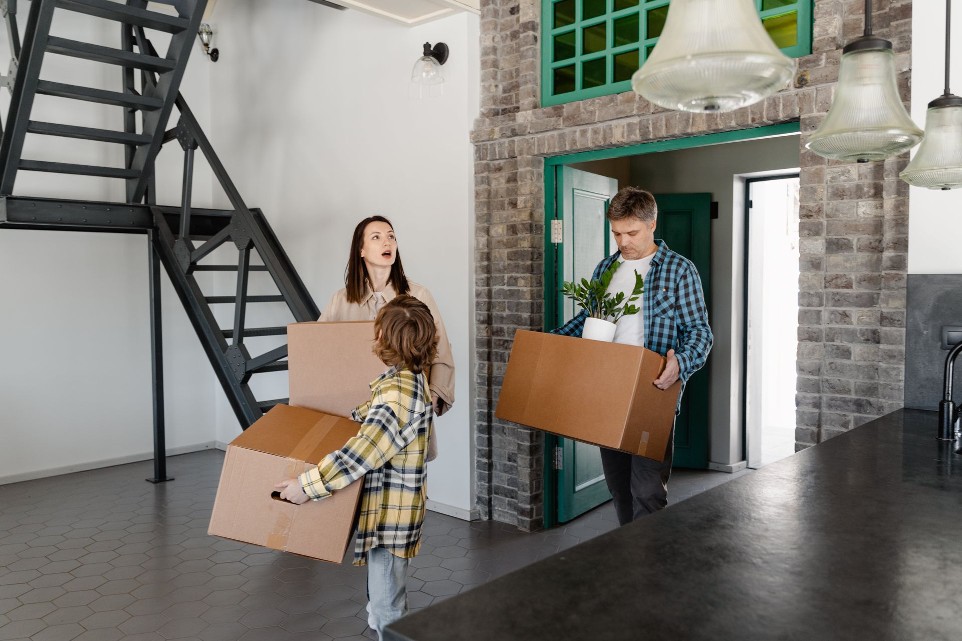 A family is carrying boxes into a new home.