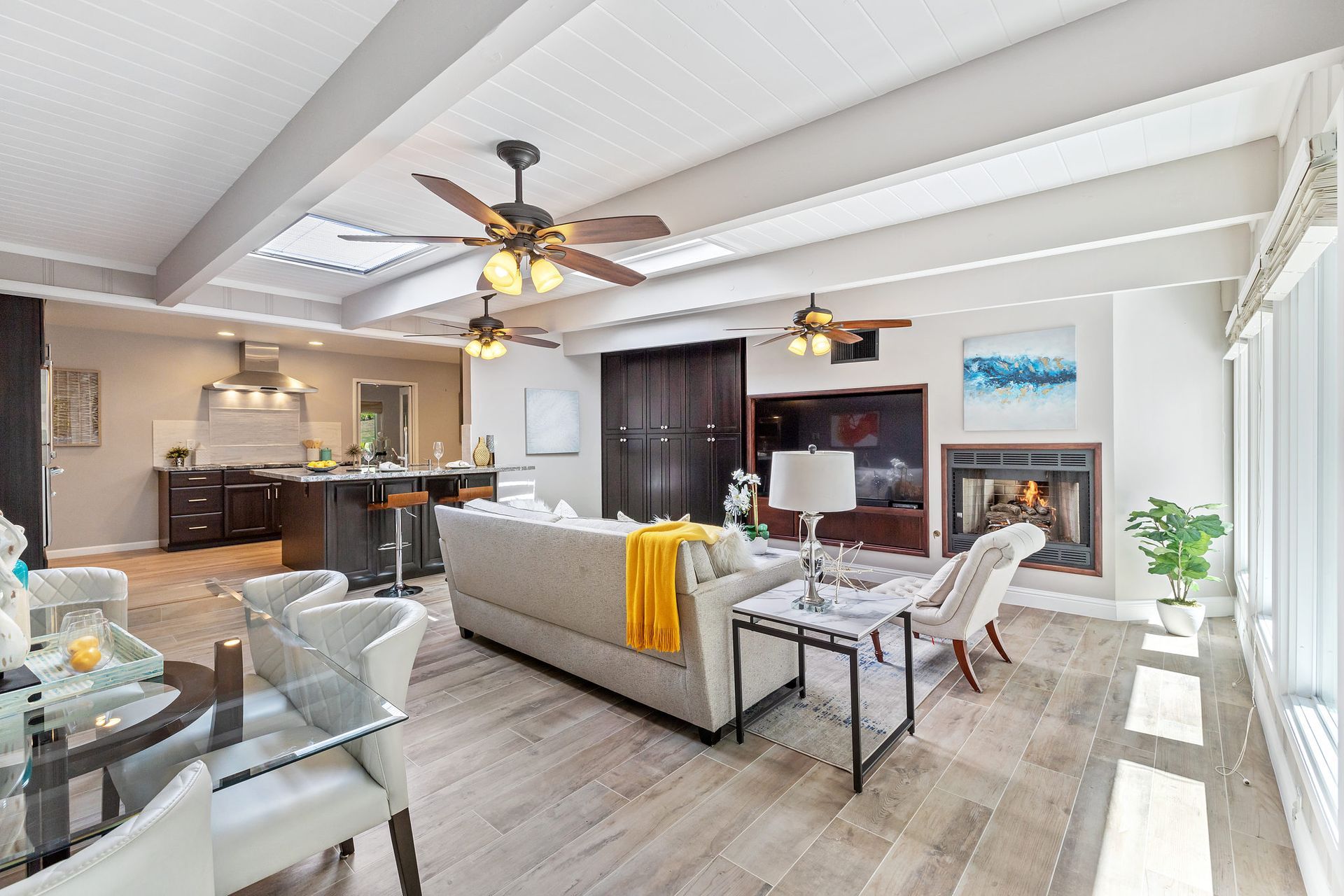 A living room with a couch , chairs , a table and a fireplace.