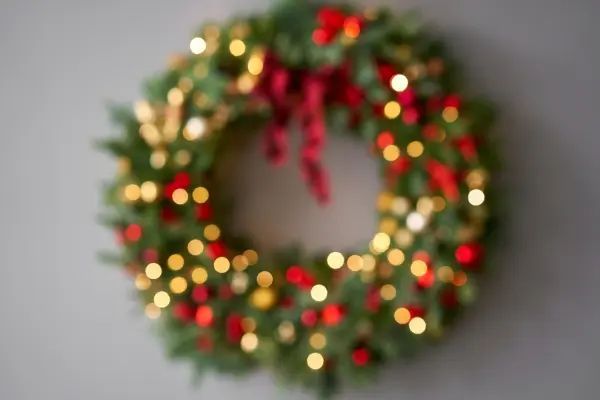 A blurry picture of a christmas wreath hanging on a wall.