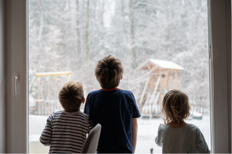 The Johnson family admiring the snow while standing in front of their new window done by Knoxville Doors and Windows