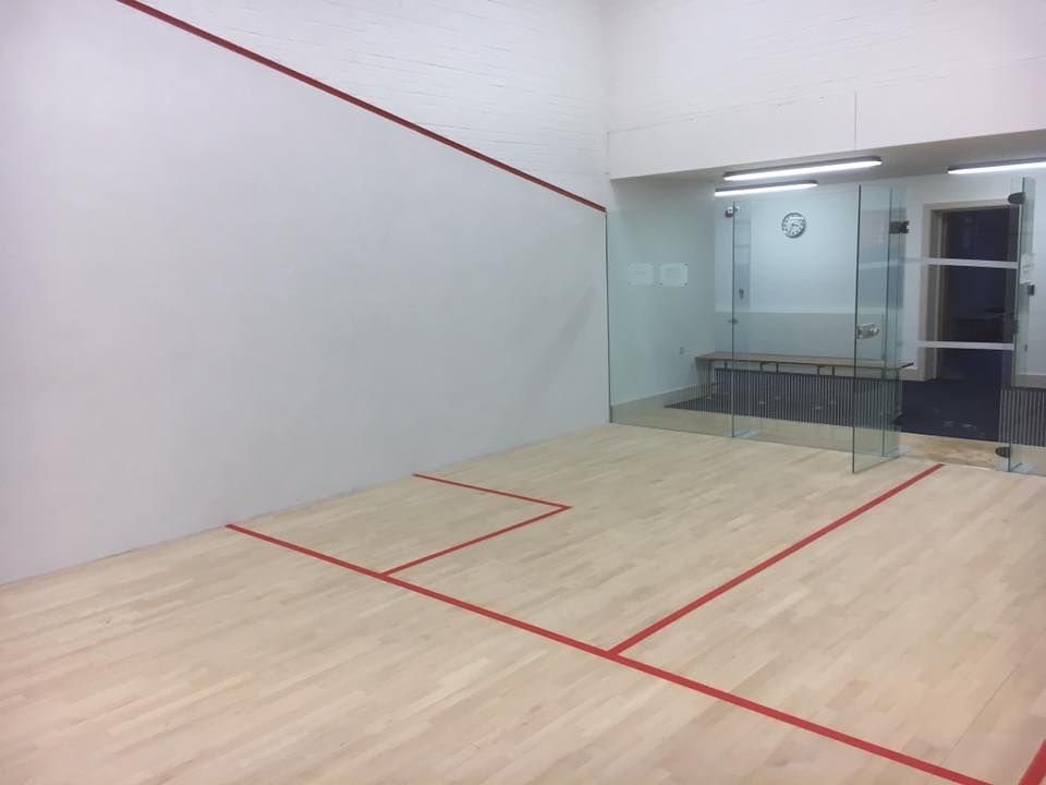A squash court with a red line on the floor