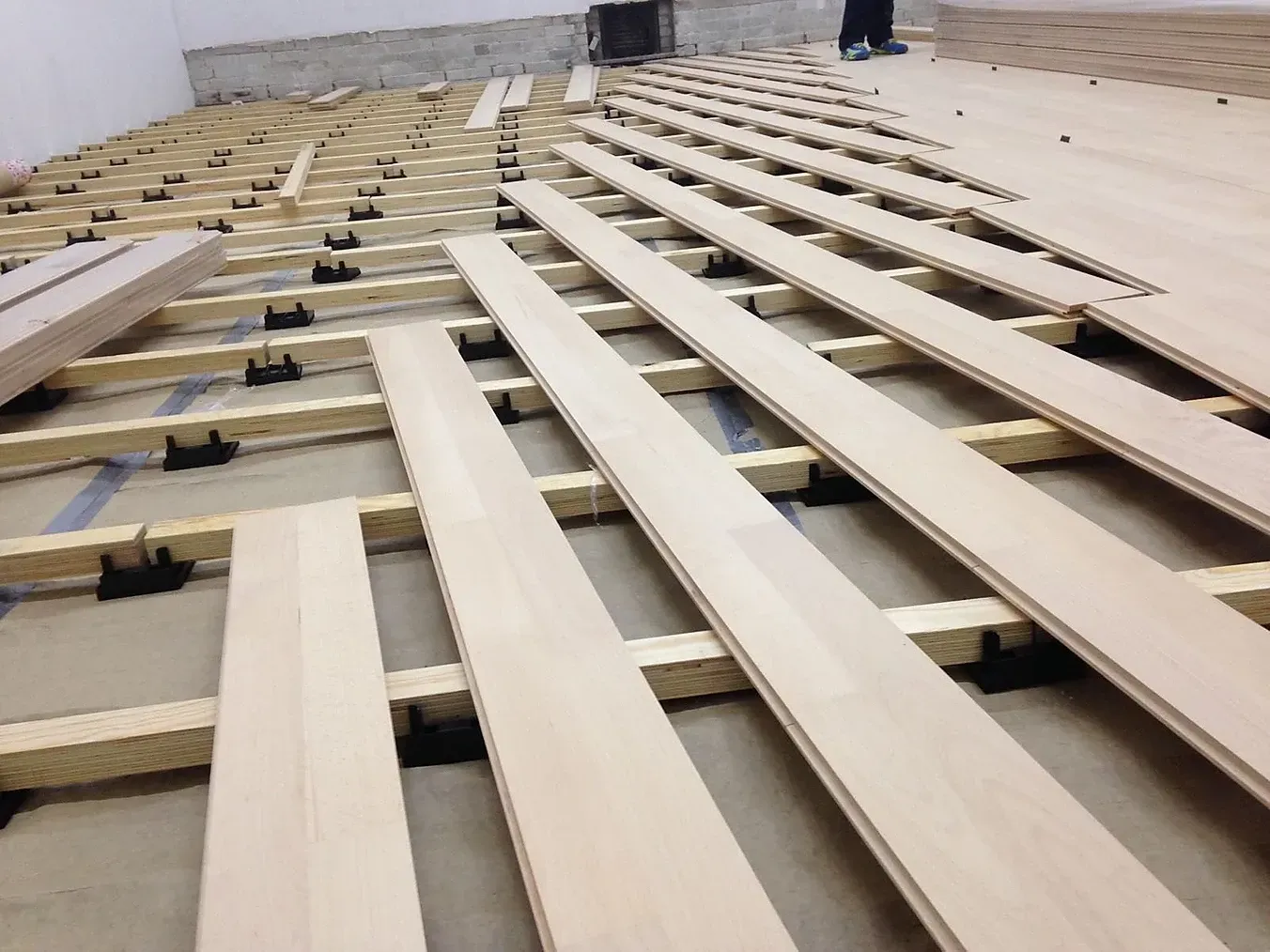 A wooden floor is being built in a squash court