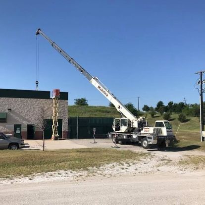 A white crane is parked in front of a building