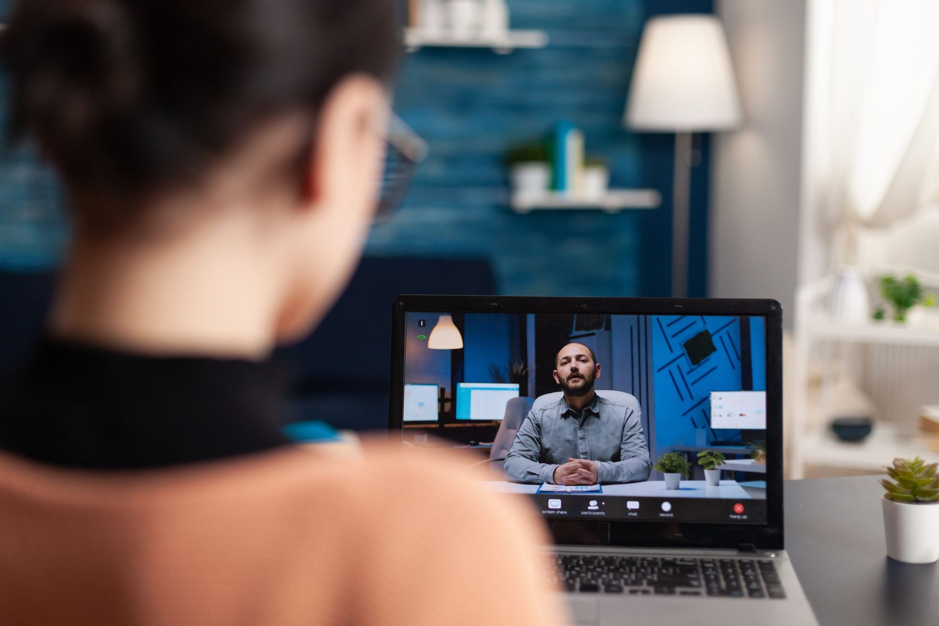 A woman is sitting in front of a laptop computer having a video call with a man.