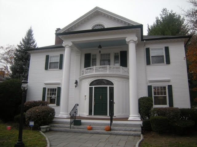 A large gray house with a black roof and two garage doors