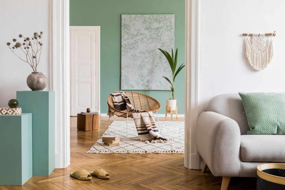 A living room with a couch , chair , rug and green walls.