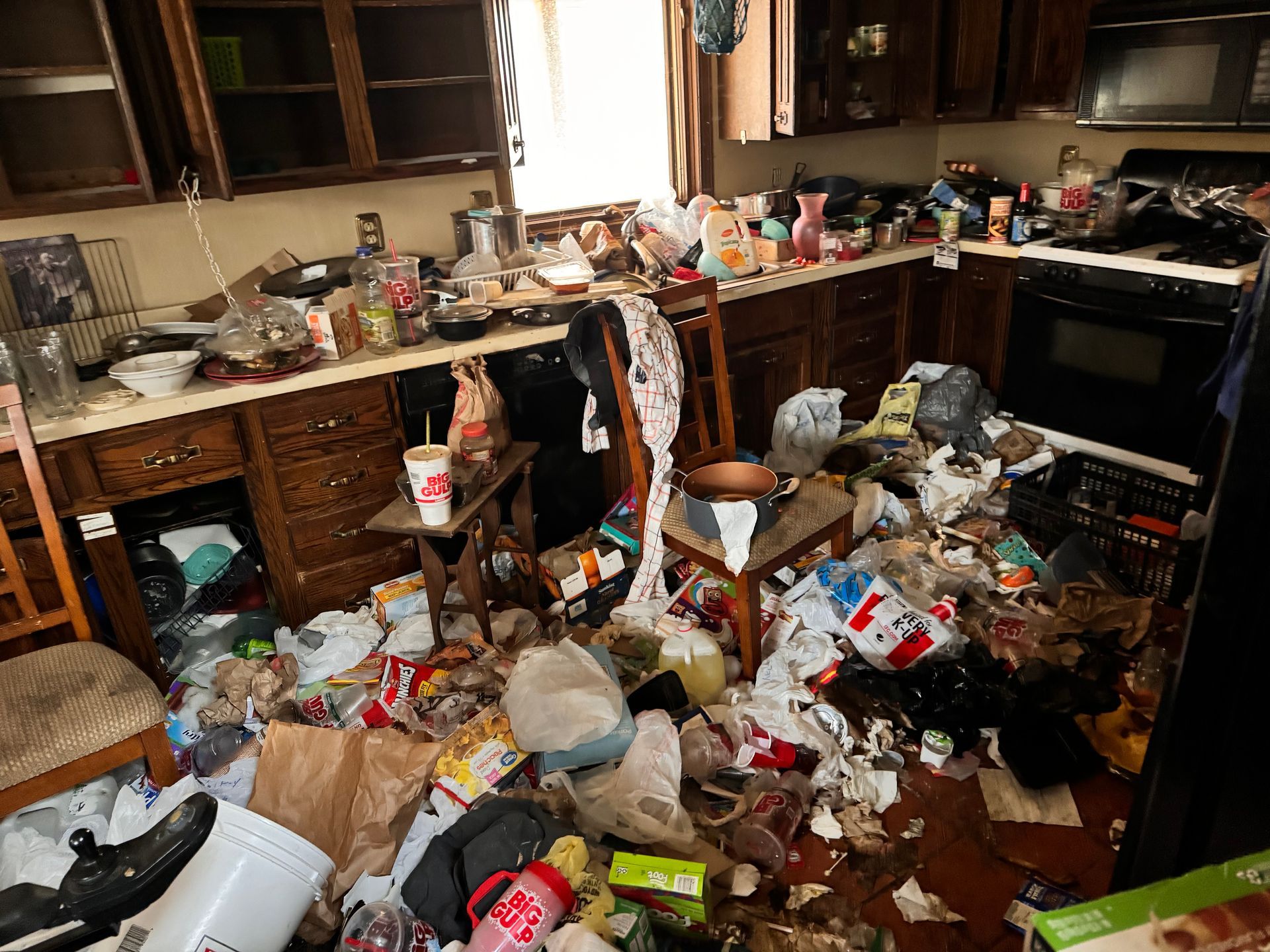 A messy kitchen with a lot of junk on the floor.