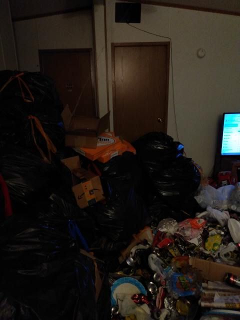 A living room filled with lots of garbage and a television