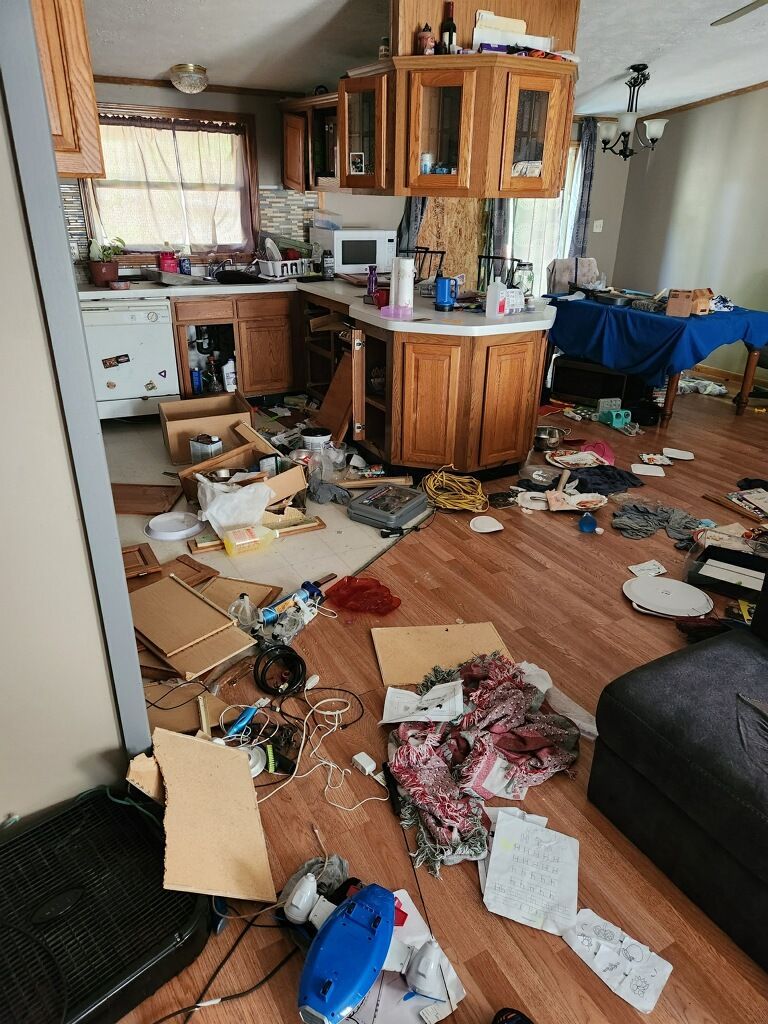 A messy kitchen with a lot of junk on the floor.