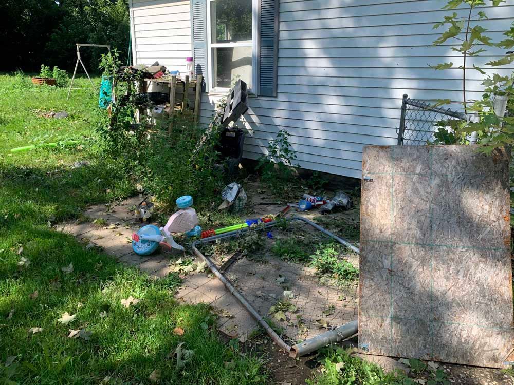 A house with a lot of junk in front of it.