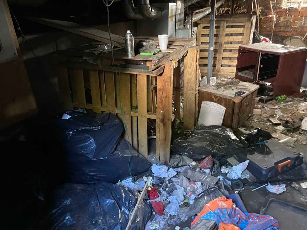 There is a lot of trash in the basement of a building.