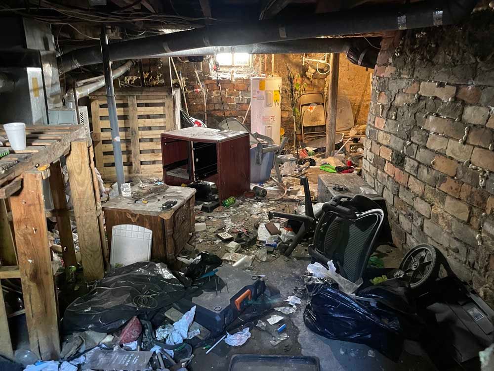 There is a lot of trash in the basement of a house.