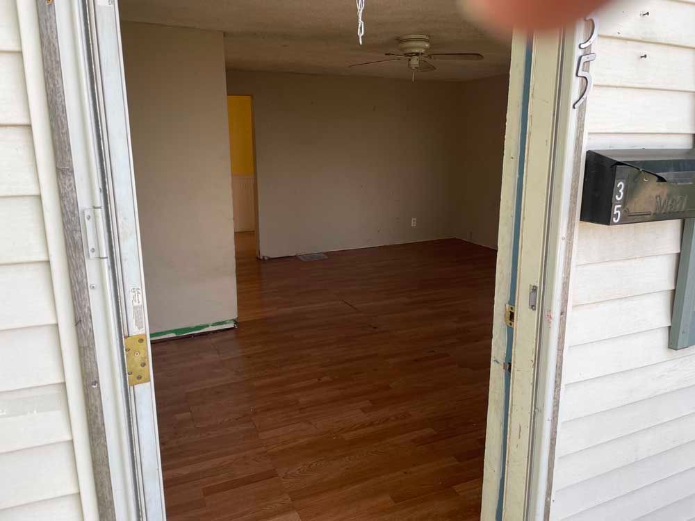 A person is standing in the doorway of an empty house.