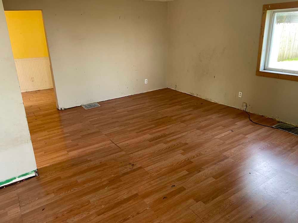 An empty room with hardwood floors and a window.