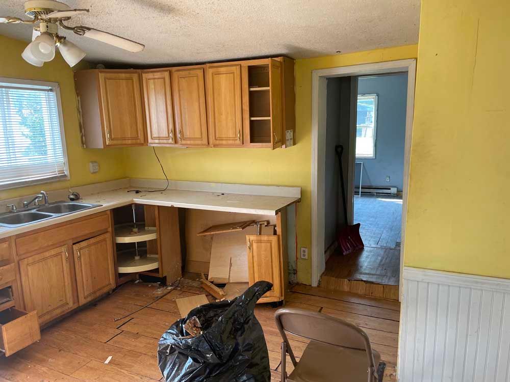 A kitchen with wooden cabinets and a ceiling fan.