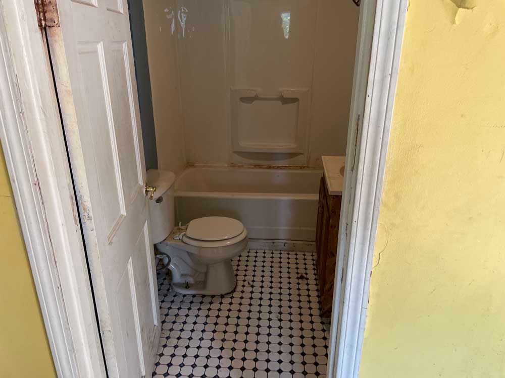A bathroom with a toilet , bathtub and sink.
