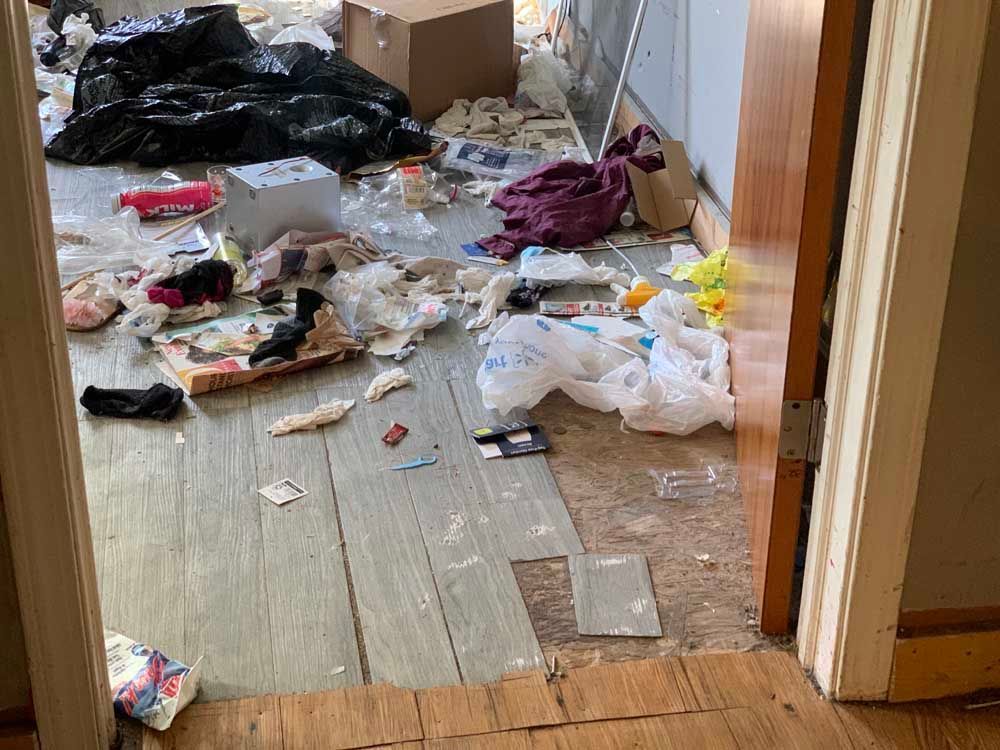 A room with a lot of trash on the floor.