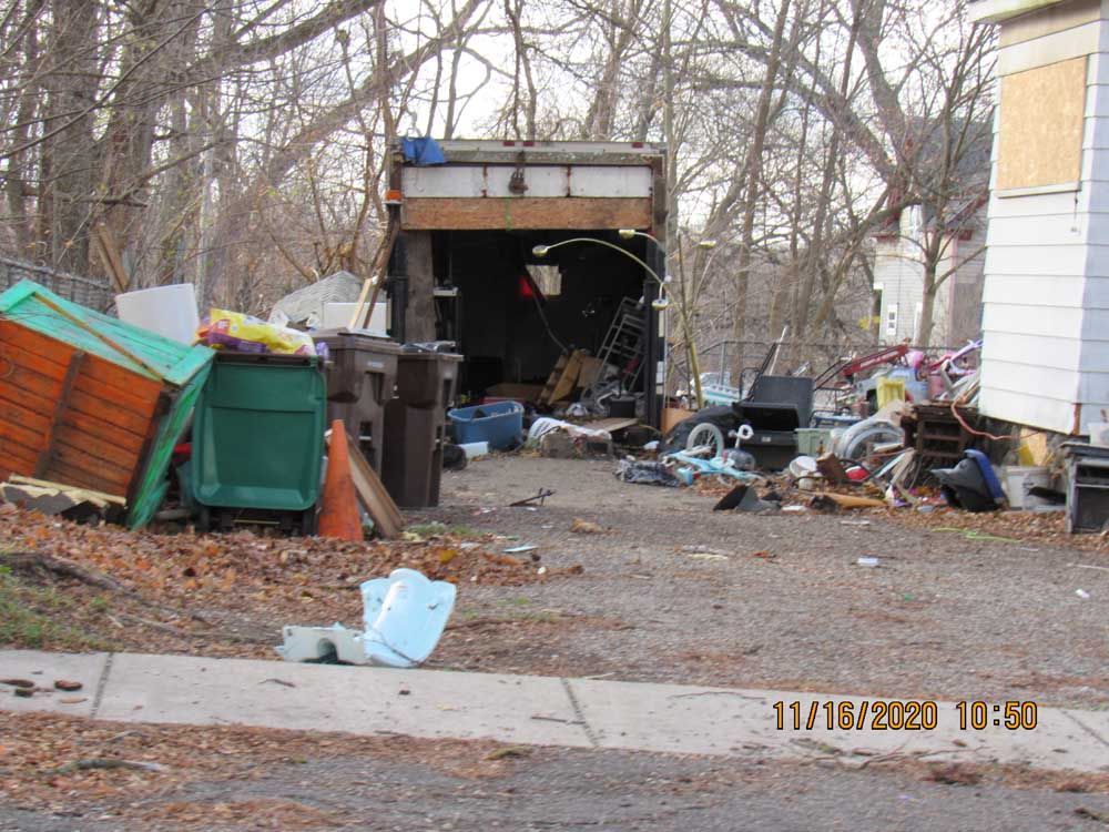 A pile of garbage is sitting in front of a house.