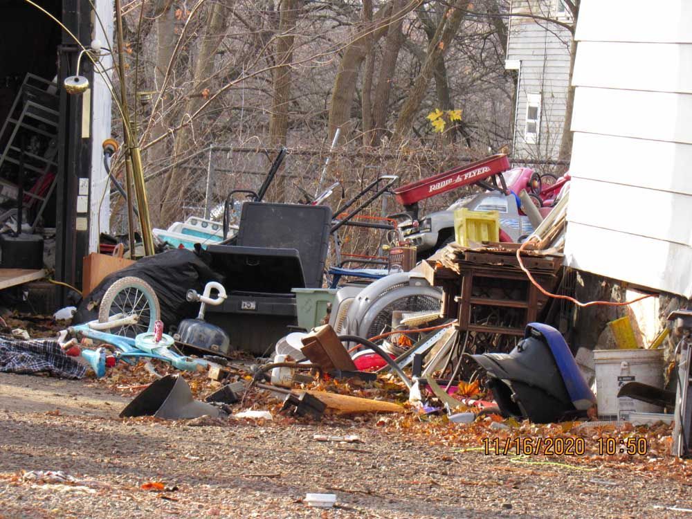 A pile of trash is sitting in front of a garage.