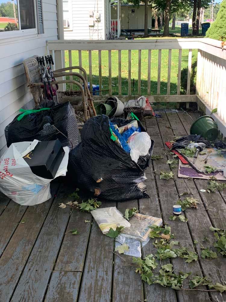 There is a lot of trash on the deck of a house.