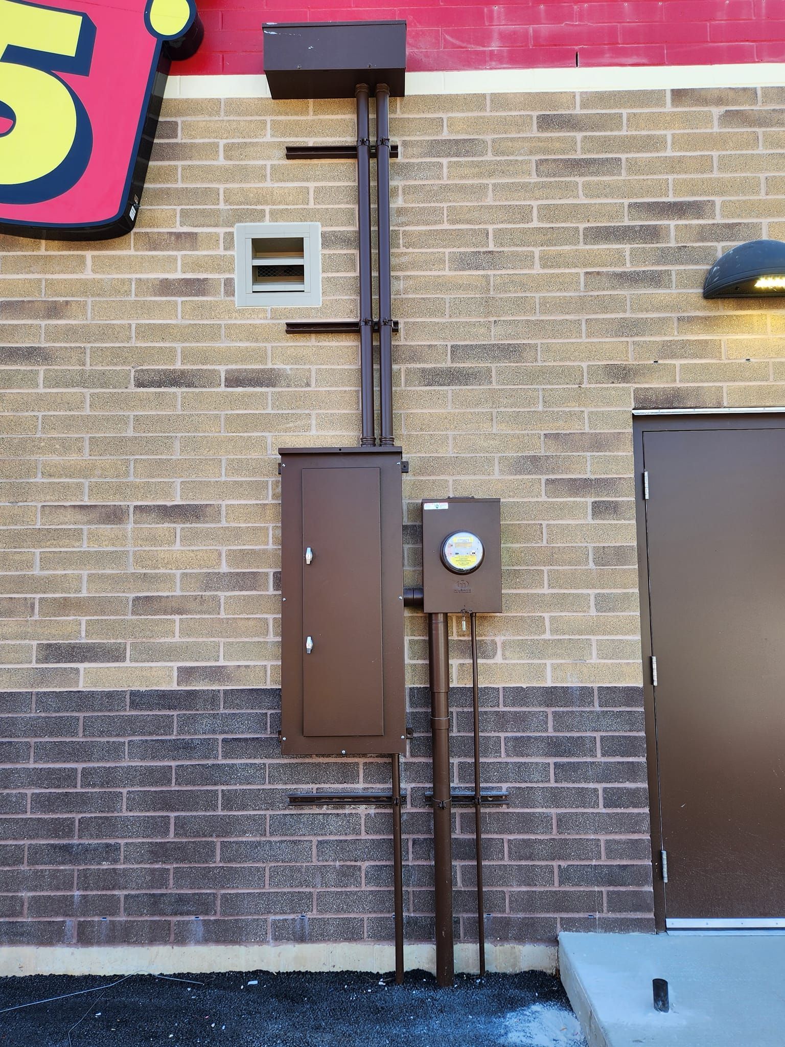 A Brick Building with a Sign.