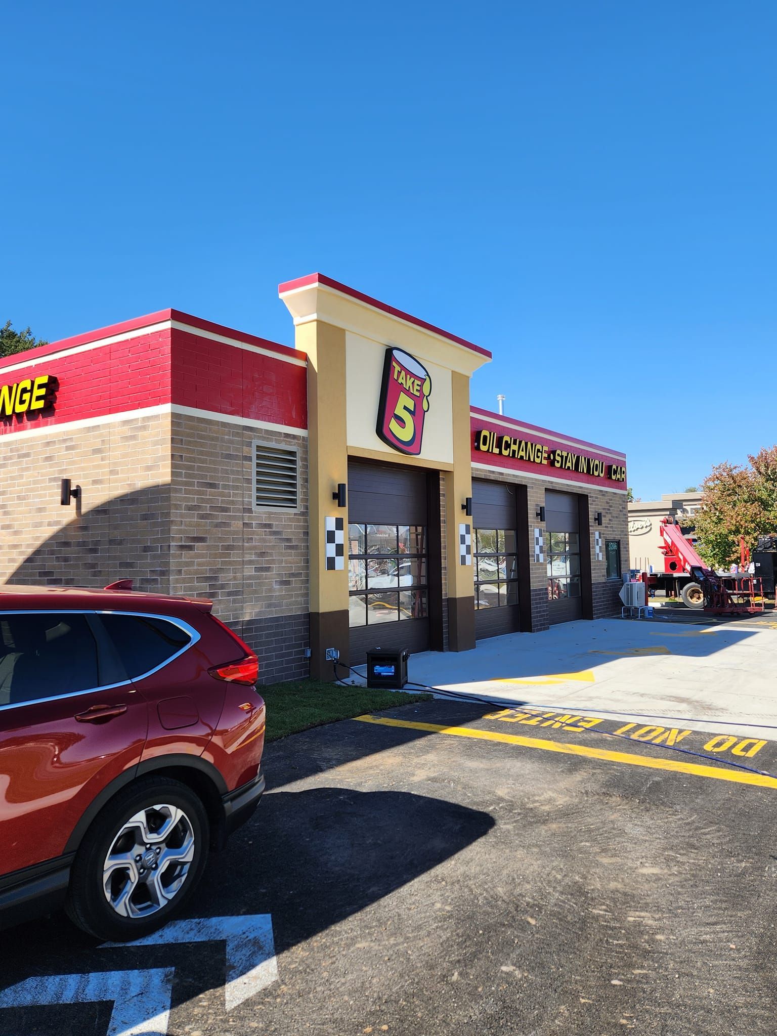 A Red SUV is Parked in Front of a Car Wash.