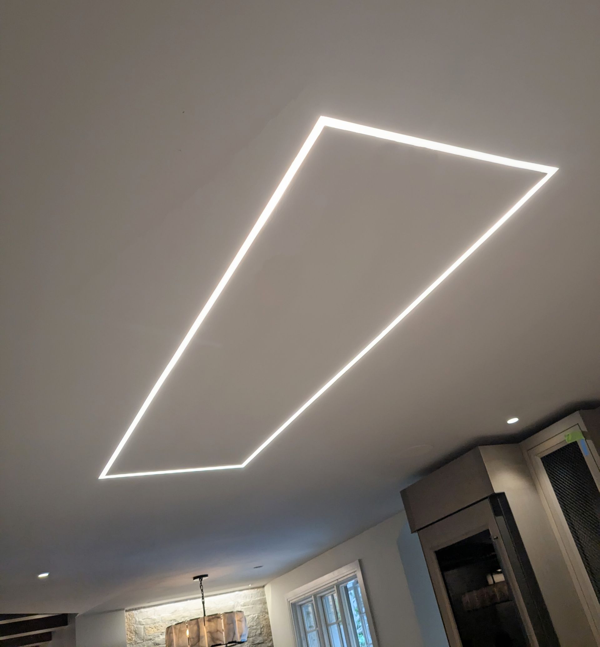Modern kitchen ceiling with a bright geometric LED light fixture