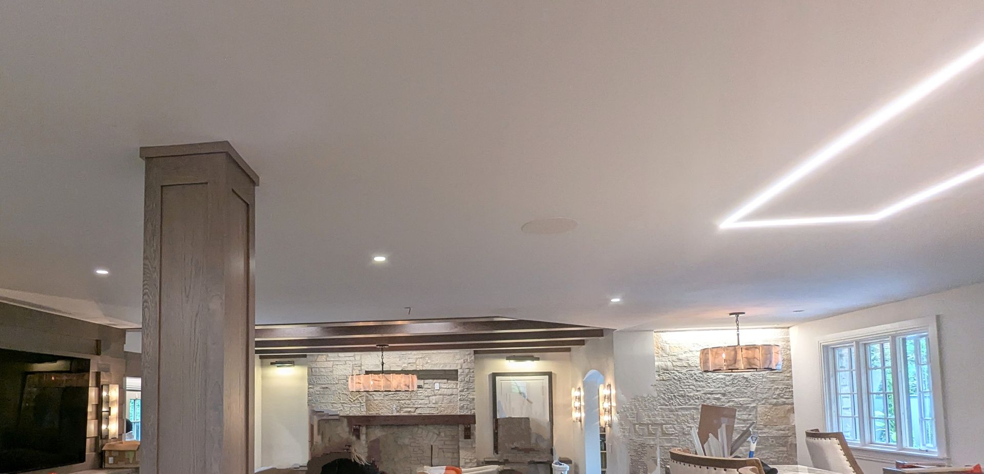 Modern living room with stone fireplace, white couch, and recessed lighting