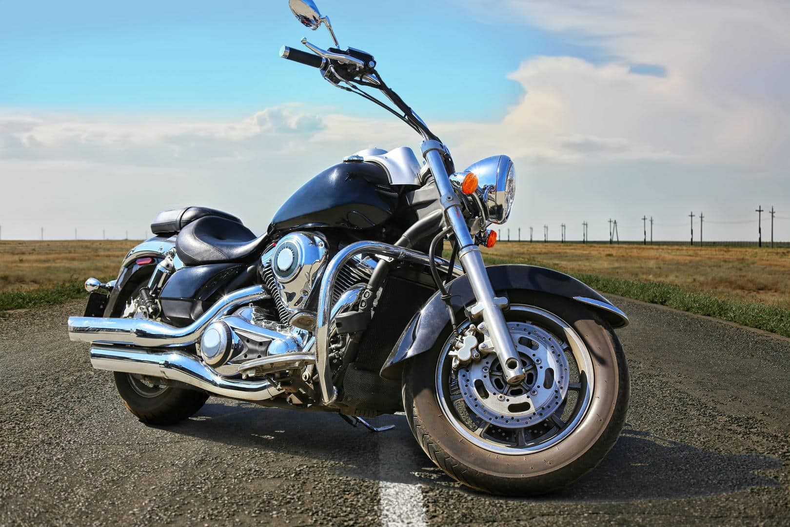A man is cleaning a black car with a cloth.