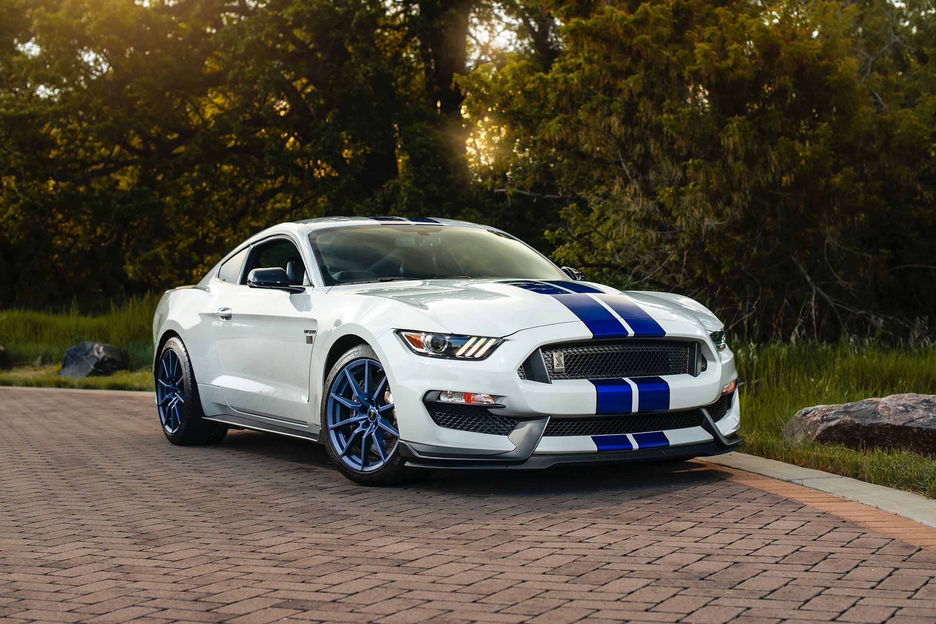 A person is polishing the headlights of a car.