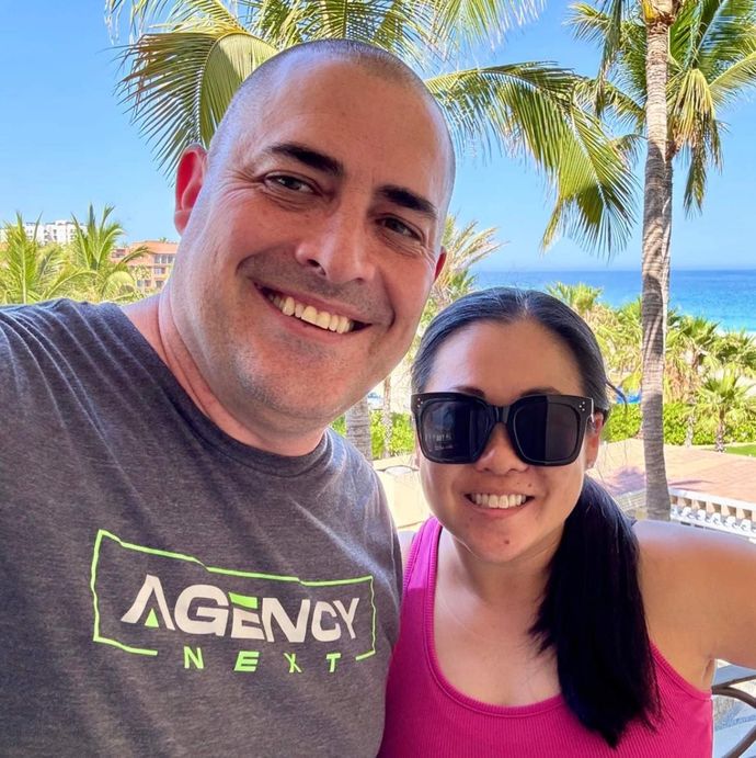 A man and a woman are posing for a picture while wearing sunglasses.