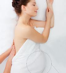 Pregnant woman on her side having her back massaged