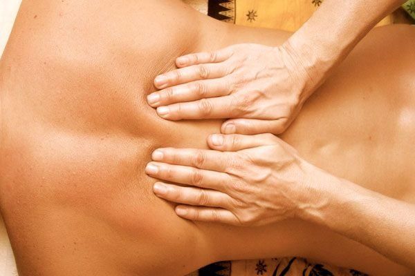 Two hands massaging back below shoulder blades