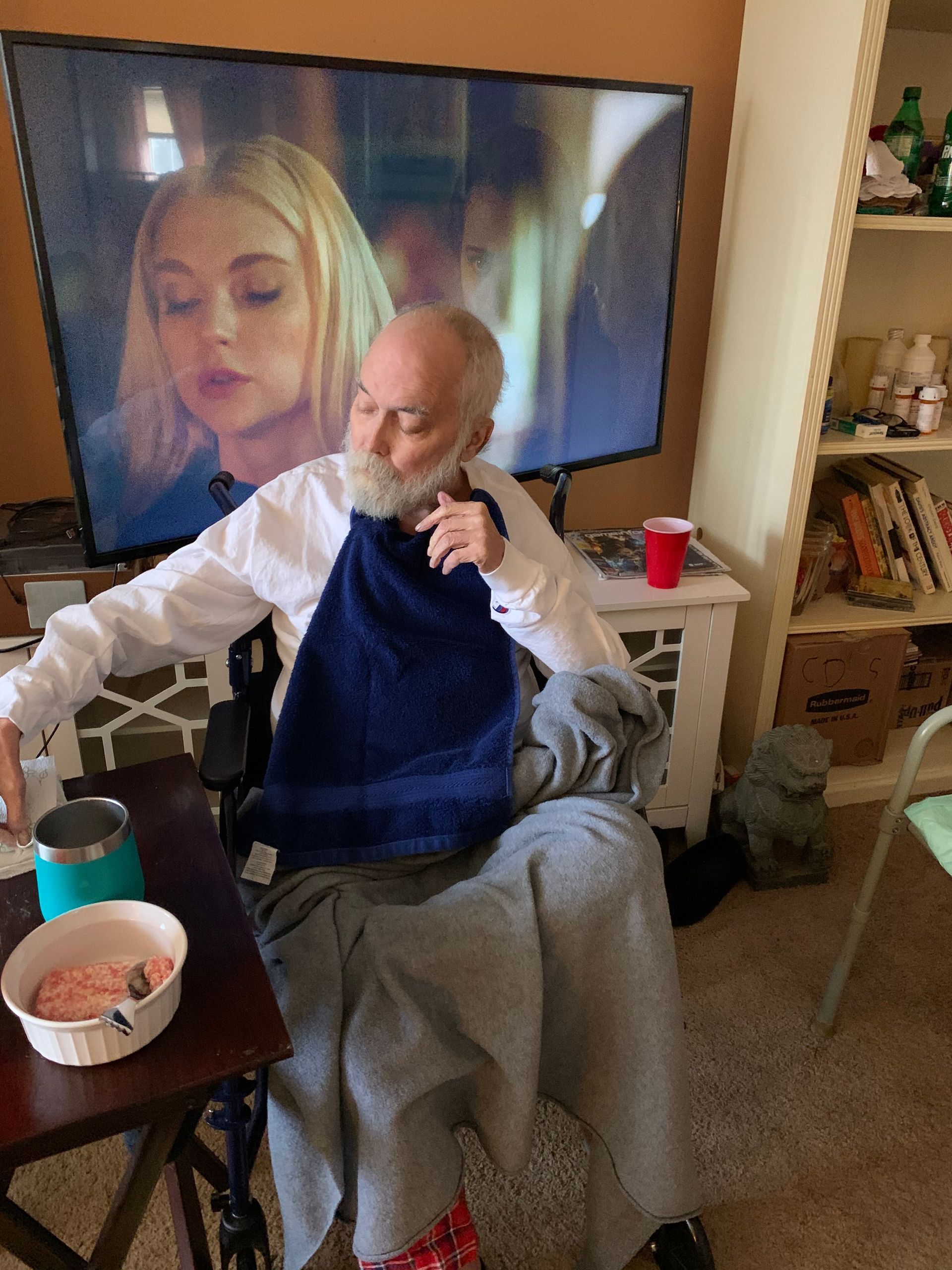 A man in a wheelchair is sitting in front of a television.