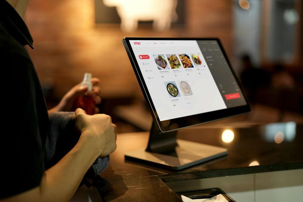A person is using a computer to order food in a restaurant.