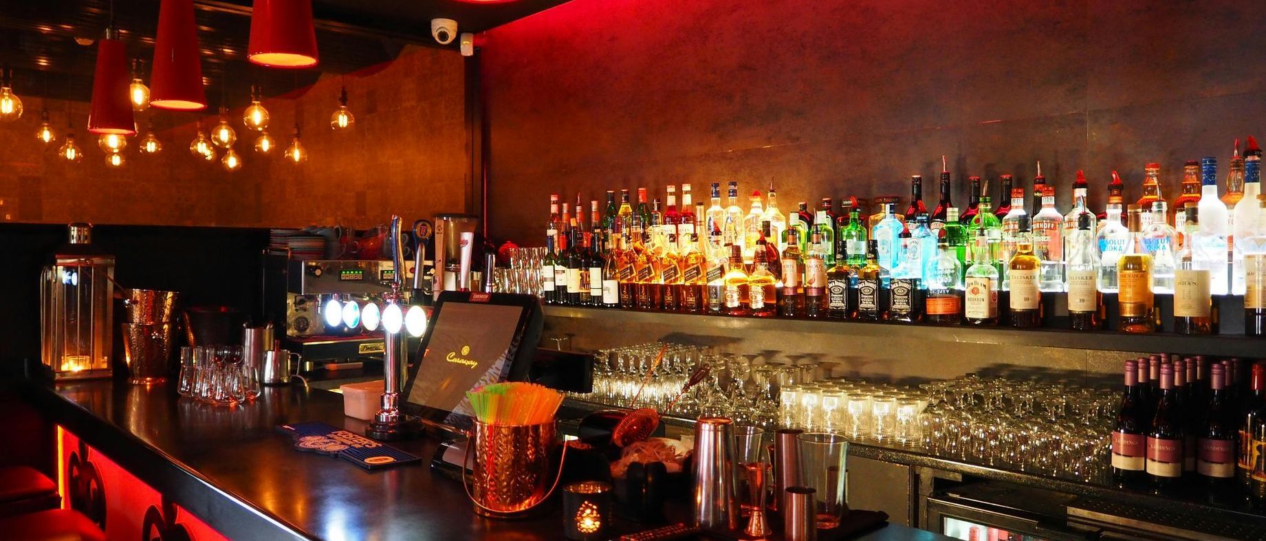 A bar with a lot of bottles of alcohol on shelves